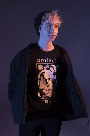 Cas stands facing the camera with  gentle glance to the right, dramatic lighting, hands in jacket pockets, slightly obscuring shirt