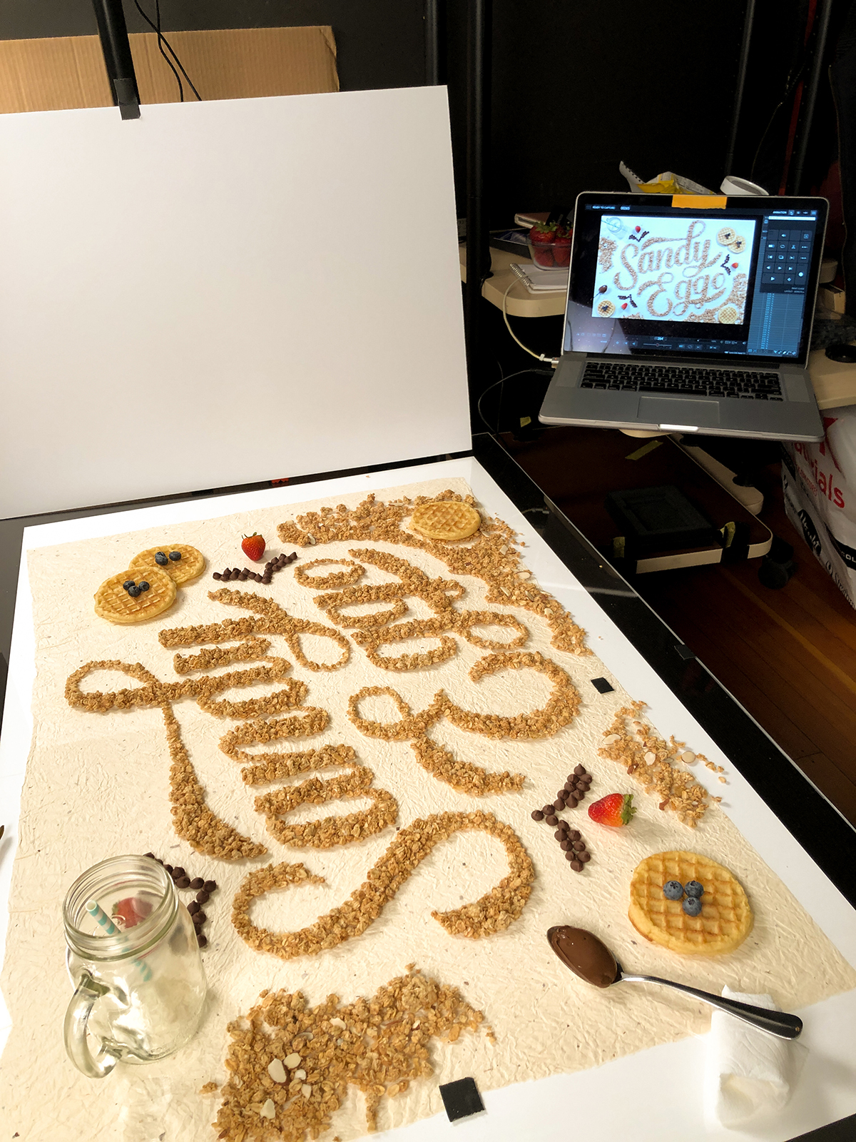 Behind-the-scenes of photo shoot for the previous image, showing the setup and detail for photographing the meticulous process of designing the image.