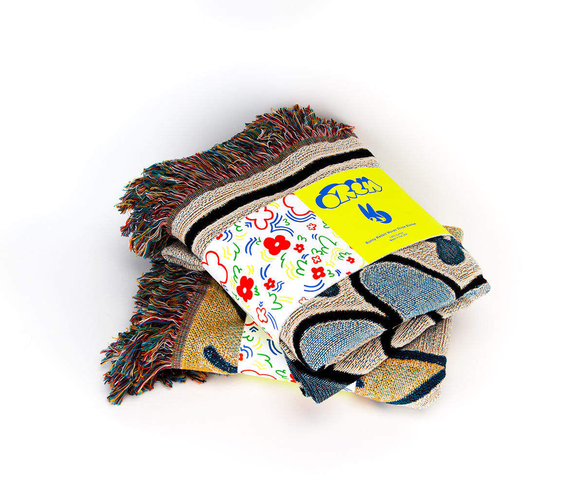 Two stacked folded quilts with packaging design, reads 'OREM' with bunny logo and flower pattern